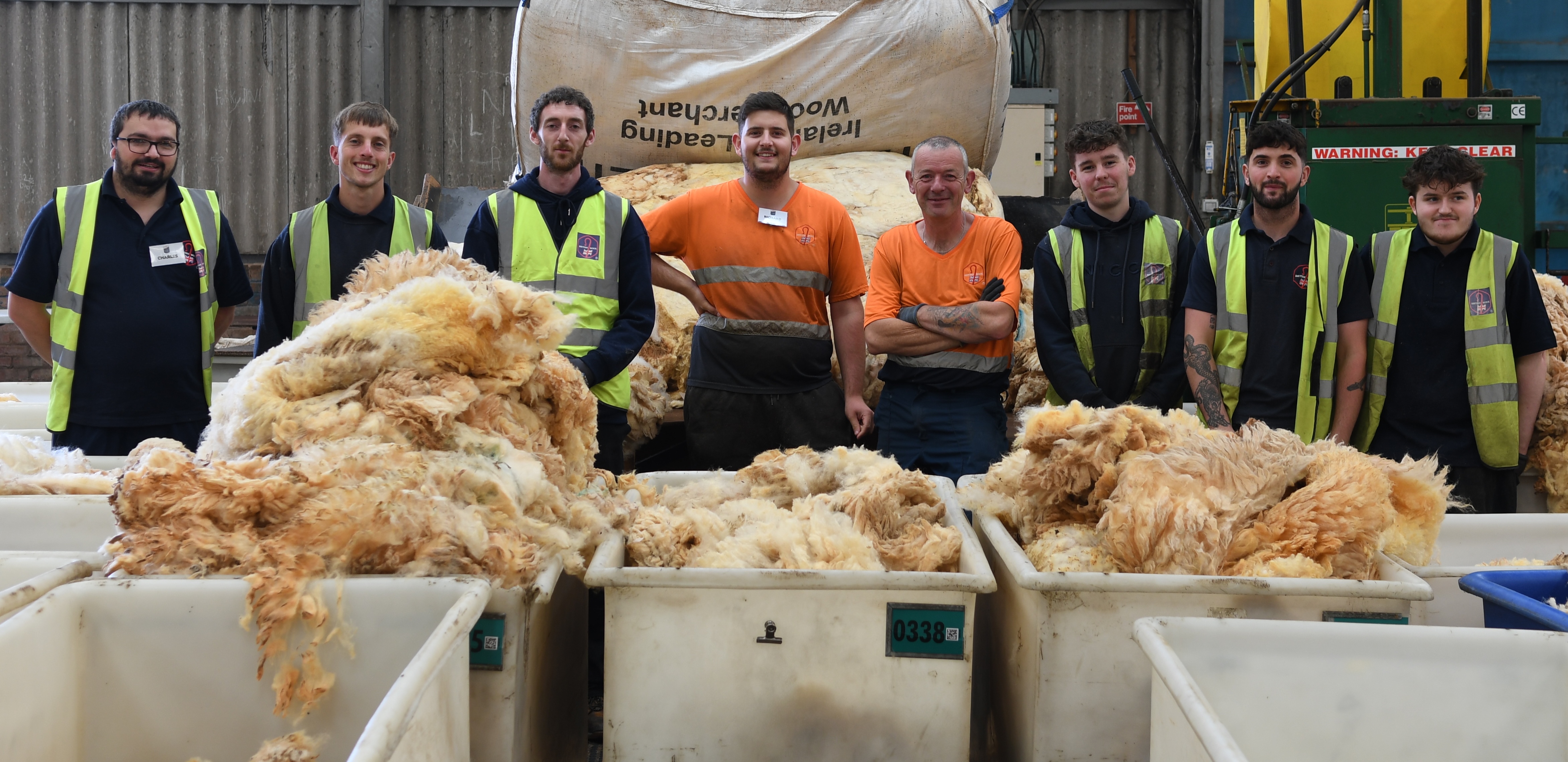 Workers with large containers of wool at British Wool