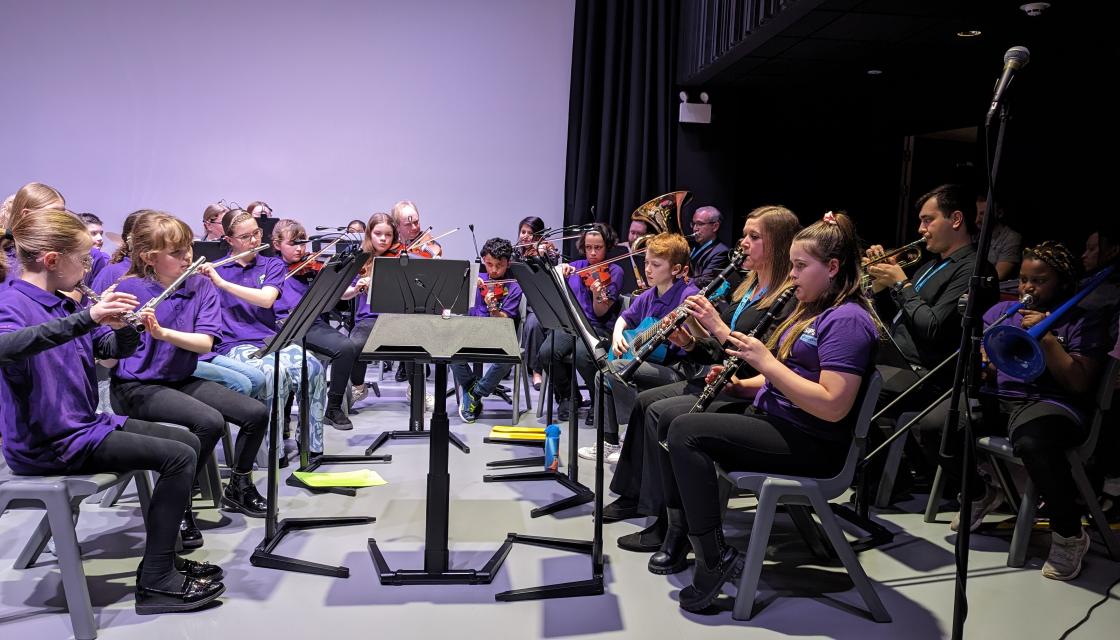 An orchestra of young people playing musical instruments