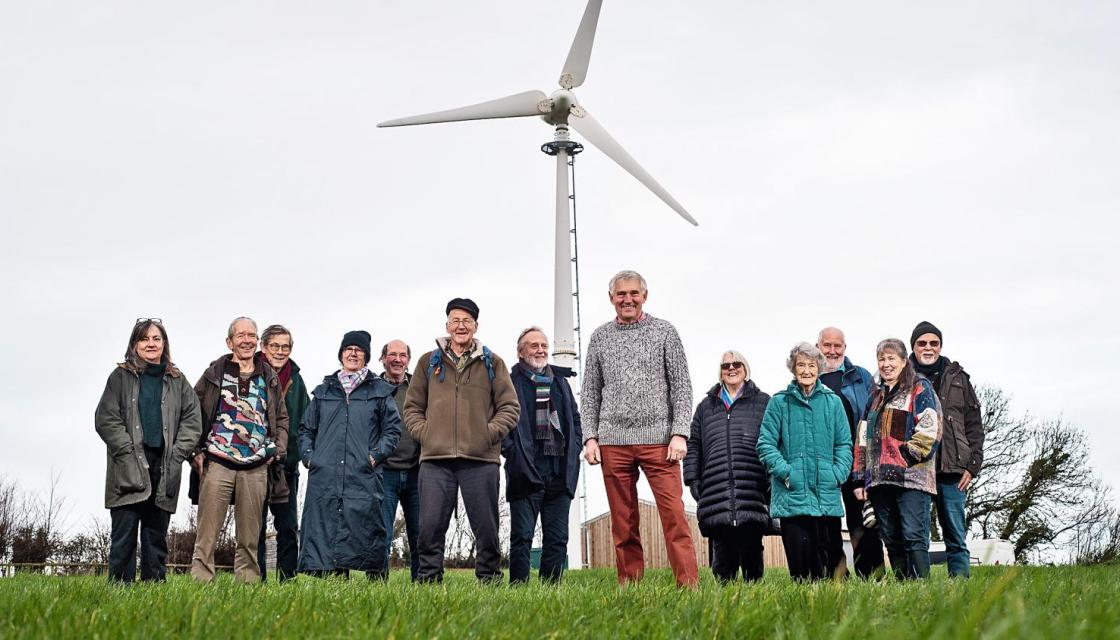 People stood in front of a wind generator