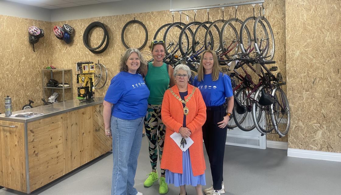 Women stood in front of a wrack of bikes at The Chichester Bike Project