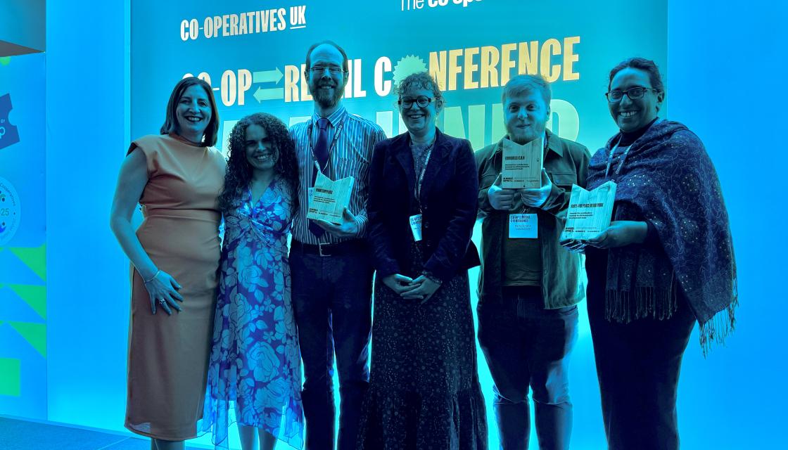 A group of people stood on stage – award winners being recognised for their efforts to deliver against the UN Sustainable Development Goals and representatives from Co-operatives UK and The Co-operative Bank