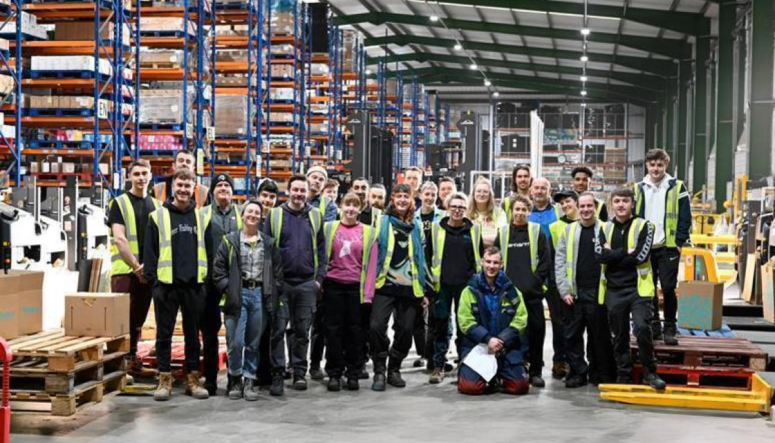 A group photograph of Suma Wholefood worker owners in their warehouse.