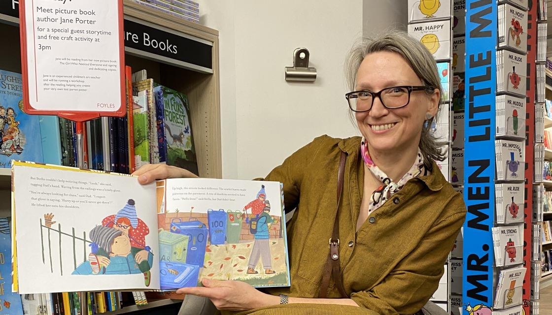 Women holding a Childs book in a library 