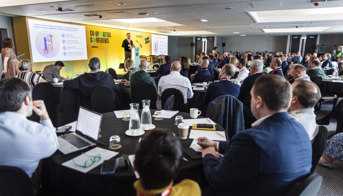 Image showing the audience listening to a speaker on stage.