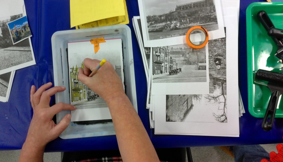 Someone doing arts and crafts, drawing a building