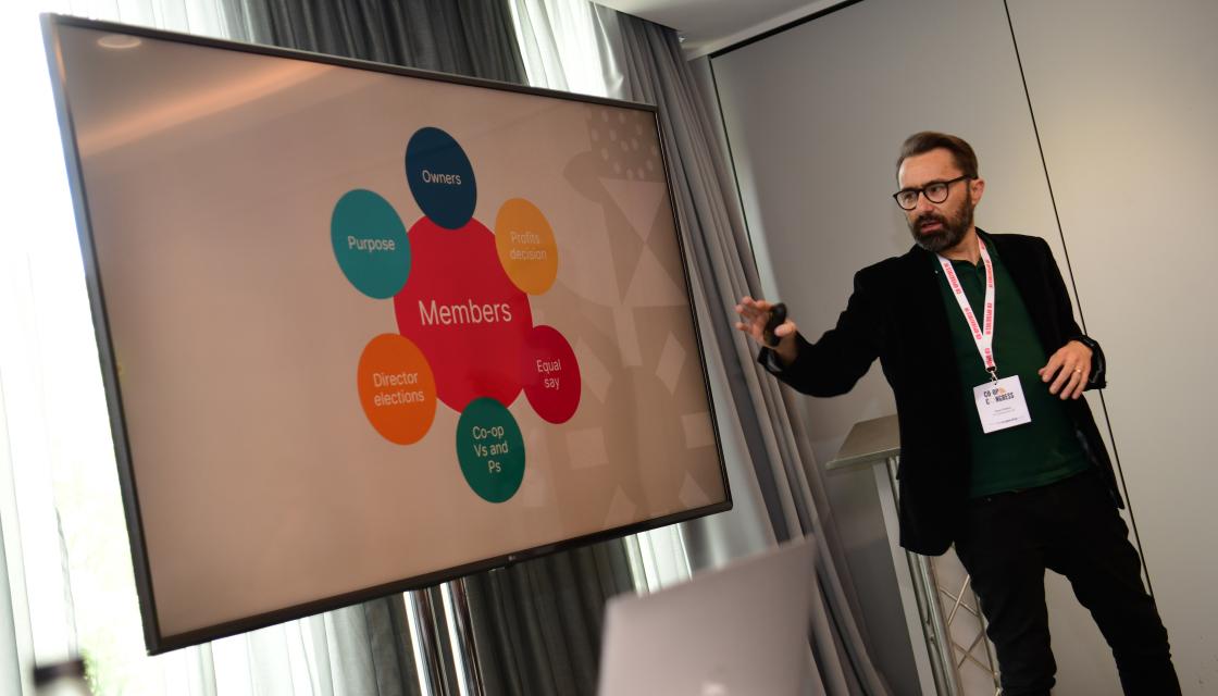 Dane Pollard stood in front a board doing a session at Co-op Congress