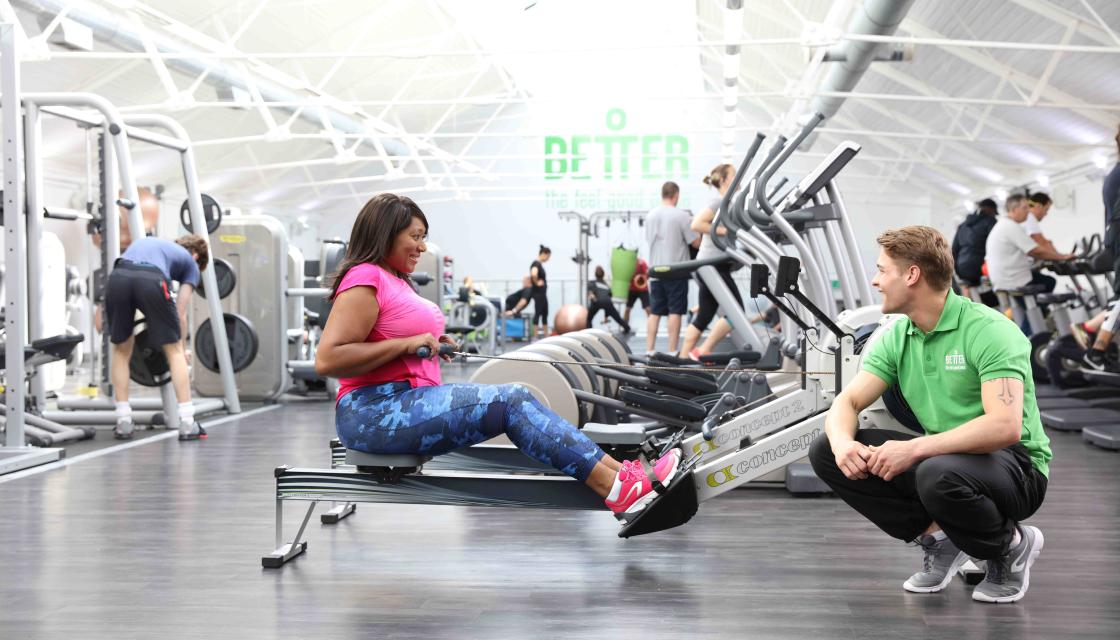 A GLL staff member personal training someone in a GLL gym