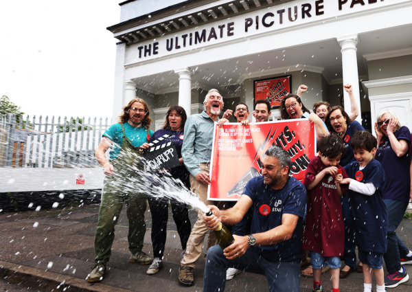 Members of Ultimate Picture Palace celebrating outside the cinema.