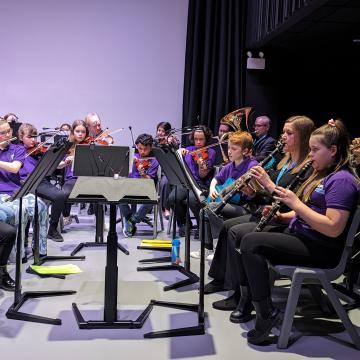 An orchestra of young people playing musical instruments