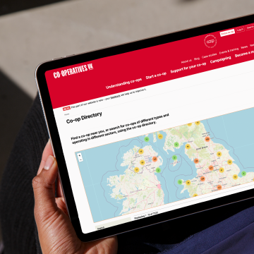 Some holding a tablet device looking at a map of co-operatives on the Co-operatives UK directory