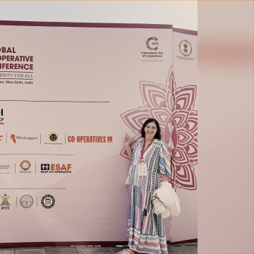 Rose Marley stood in front of a branded sign at the ICA Global Cooperative Conference 2024