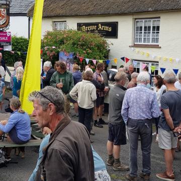 The exterior of The Drewe Arms with a crowd of people outside