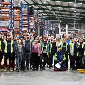 A group photograph of Suma Wholefood worker owners in their warehouse.