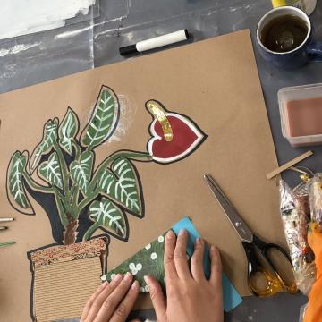 A table with hands working on an art project
