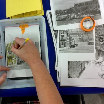 Someone doing arts and crafts, drawing a building