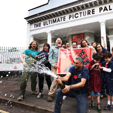 Members of Ultimate Picture Palace celebrating outside the cinema.